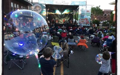 Children play with lighted balloons at the #doubledeckerartsfestival on Friday night.