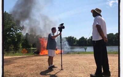 Michael interviewing a flooded resident with a pile of wood on fire in the background. #mississippijourno #umjourimc